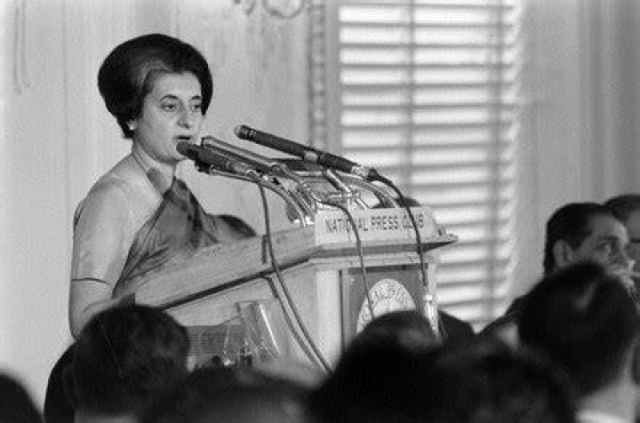Indira Ghandi speaking on a microphone
