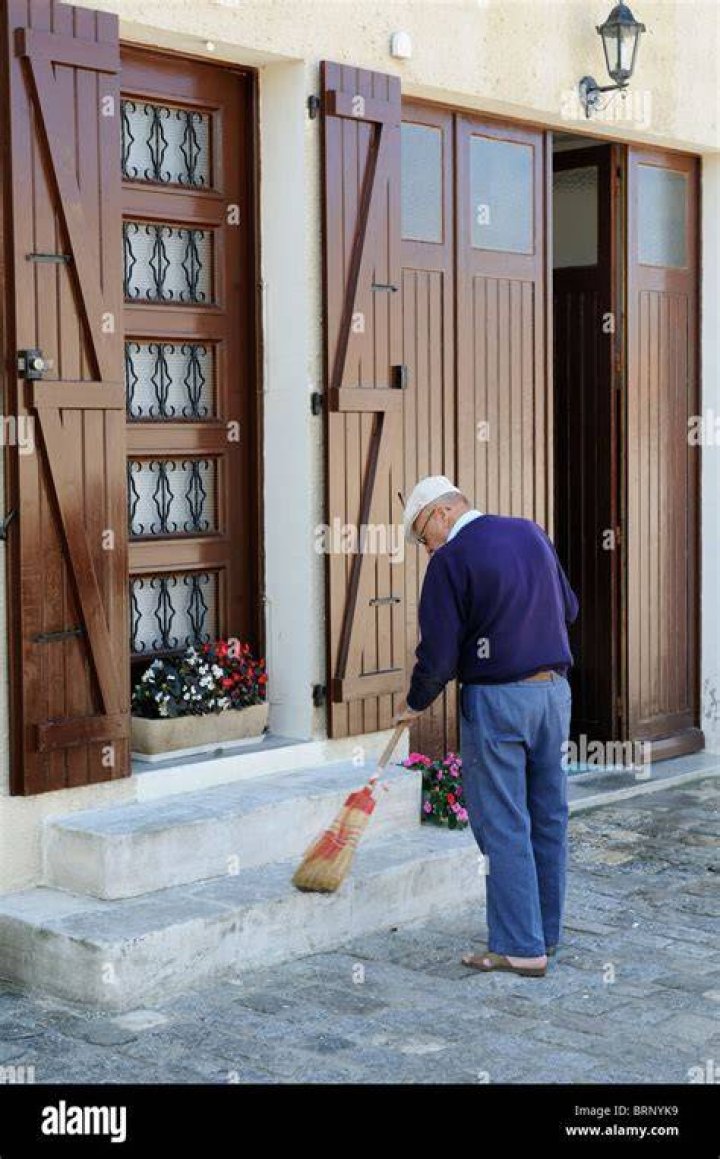 Man sweeping the step front of a jewelry shop in Tanzania
