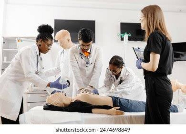 Medical students practicing on a medical dummy