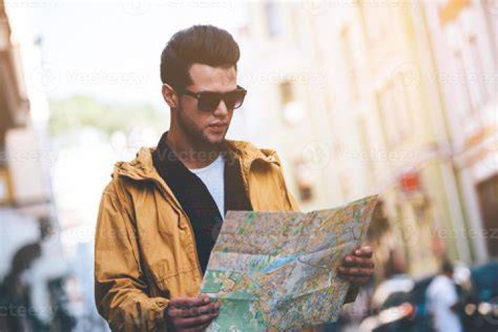 person looking at map on street corner