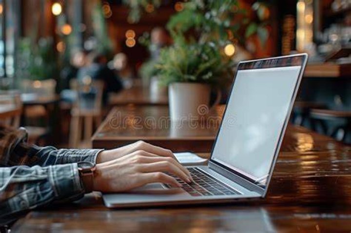 person sitting at table using a laptop
