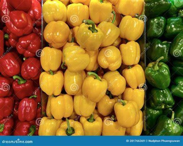 Red, yellow and green Bell Peppers red, yellow and green bell peppers are seen stacked side by side in a farmers market display