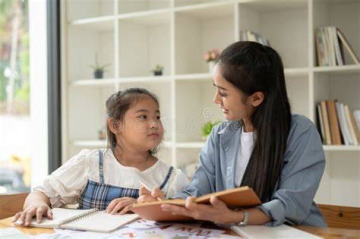 Young girl studying with teacher
